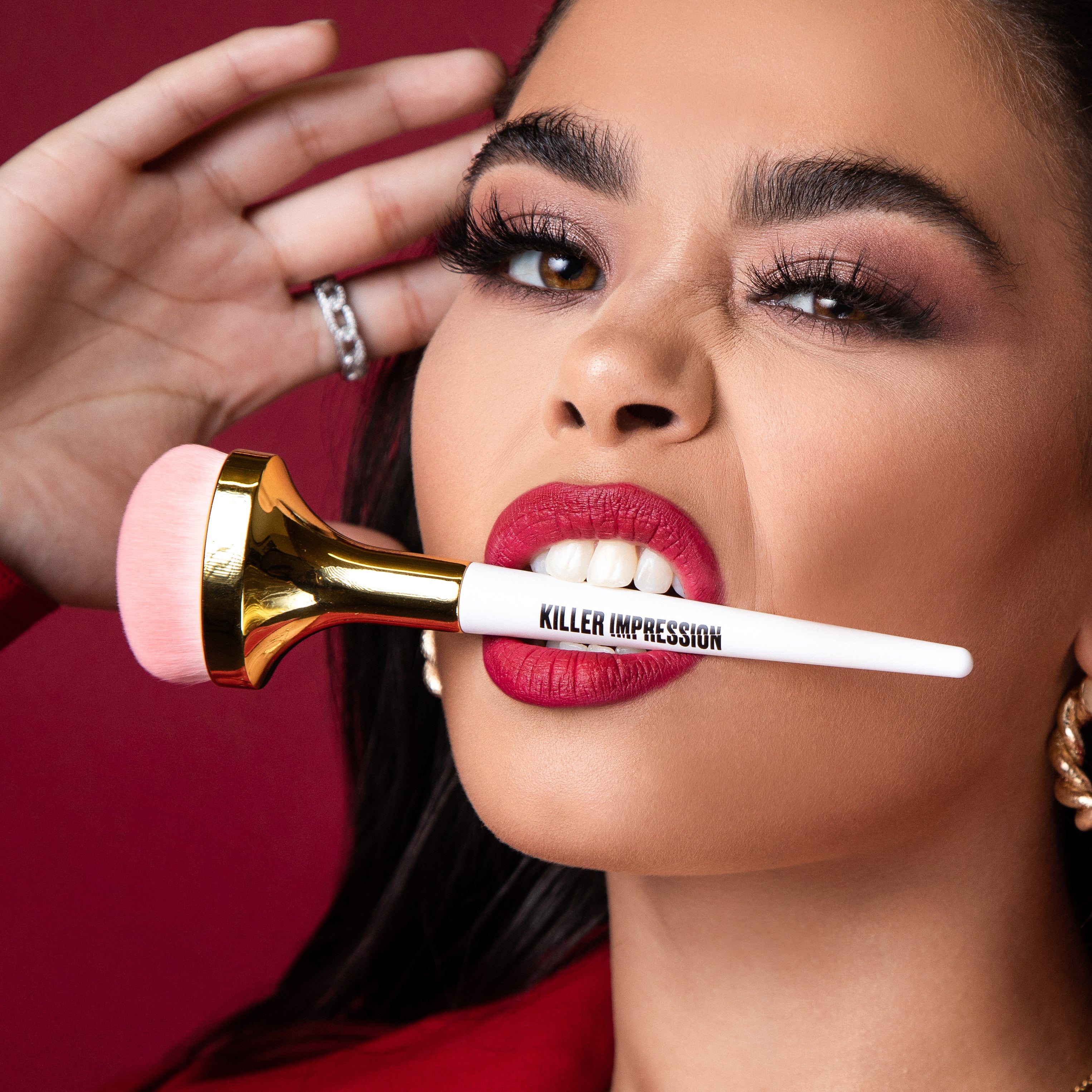 Model posing with Killer Impression Killer Base brushes in her mouth