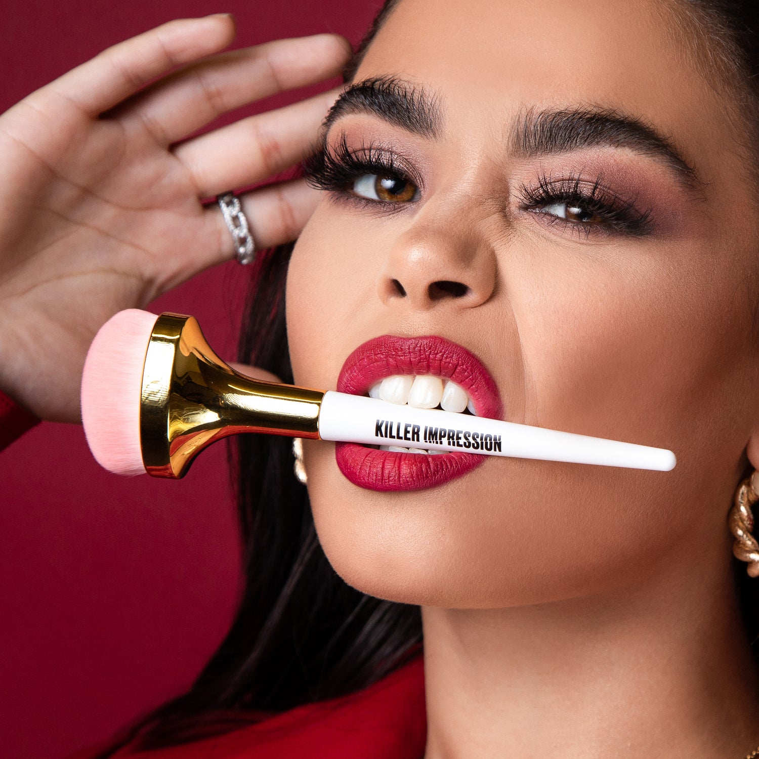 Model posing with Killer Impression Killer Base brushes in her mouth